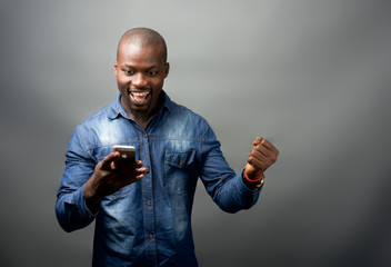 African man excited at mobile phone