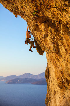 Rock climber on challenging route at sunset