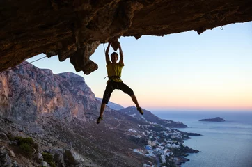 Gardinen Male rock climber gripping handhold on ceiling in cave © Andrey Bandurenko