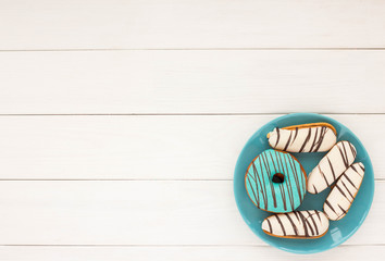 Donuts and cookies on white wooden background. Flat lay.