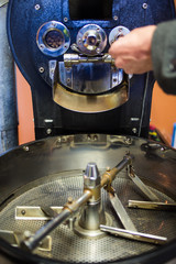 Freshly roasted coffee beans being poured into the cooling down rotator, with motion blur