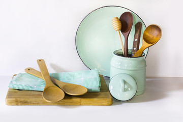 Crockery, tableware, utensils and other different white and turquoise stuff on white table-top. Kitchen still life as background for design.  Image with copy space.