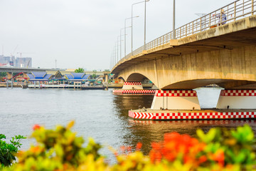 Pier and arch bridge over Chao Phraya river. It is in Bangkok, Thailand.