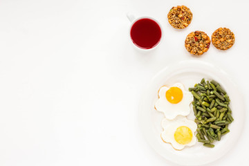 Healthy breakfast. Juice with berries, cookie with muesli and nuts, fried eggs, green beans on white background. Flat lay