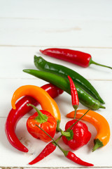 Chilli peppers mix. Orange, green and red. White background.