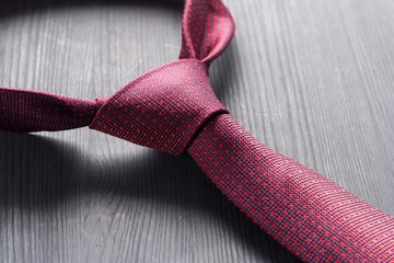 Tied red a tie on a dark table.