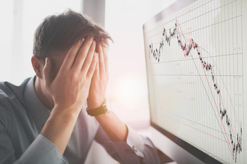 Frustrated stressed shocked business man with financial market chart graphic going down on grey office wall background. Poor economy concept. Face expression, emotion, reaction - obrazy, fototapety, plakaty