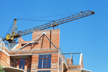 Fototapeta premium Building crane and building under construction