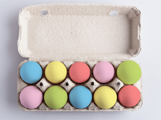 Box with painted multicolor eggs on white background