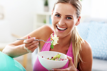 Fototapeta Young woman eating healthy salad after workout obraz