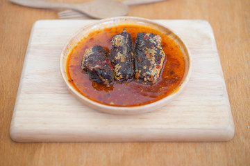 Fried mackerel in chilli sauce on wooden dish