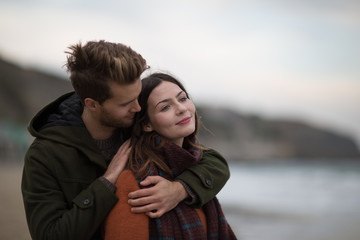 Young adult couple hugging on beach