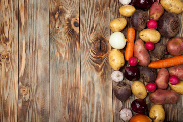 Vegetables. Potatoes, carrots, onions, beets and radishes on a rustic background