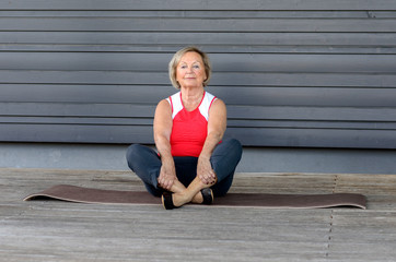 Senior woman doing exercises on a gym mat