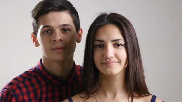 Young couple from Eastern Europe, look at camera in studio and smile sincerely