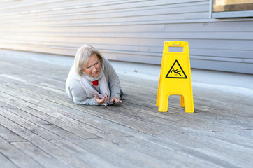 Senior lady slipping and falling on a wet surface