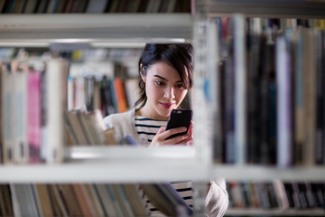 Student using smartphone in library