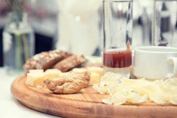 Different delicious cheeses brie, blue cheese, rosette of swiss cheese Tete de Moine, cheese of thyme with nuts and dressing on wooden round board. Low key tone.