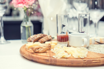 Different delicious cheeses brie, blue cheese, rosette of swiss cheese Tete de Moine, cheese of thyme with nuts and dressing on wooden round board. Low key tone.