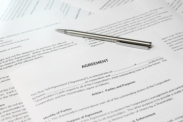 Fototapeta premium Contract papers with a pen on the table. The documents is ready to be filled out.