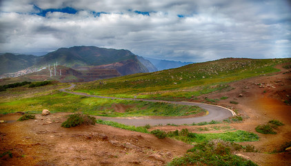 Mountains, green grass, windmills and a cloudy sky. Portugal, Madeira Island, Ponta do Rosto