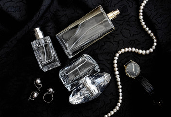 Женские духи в стеклянном флаконе на черной ткани с аксессуарами © danysharipova