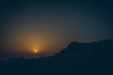 Beautiful view of amazing tropical scenery with mountain valleys above wide open sea in golden evening light at sunset with blue sky and clouds in summer, Canary Islands, Spain