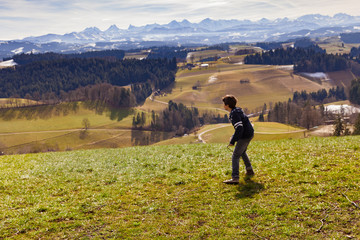 Fototapeta na wymiar Boy throws stick, mountain landscape, the concept of anger