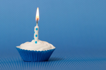 blue birthday cupcake with burning candle