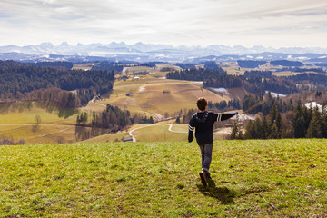 Boy throws stick, mountain landscape, the concept of anger