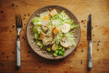 Delicious salad with croutons, grilled chicken breast, grated parmesan cheese and cos lettuce, with sauce, simply and healthy recipe, horizontal top view