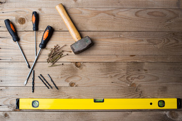 Overhead image of tools, ready for DIY project on a wooden background