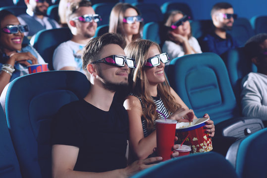 Positive Couple Drinking Cola And Eating Popcorn In Cinema.