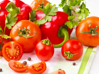 Fresh vegetables tomato, pepper, greens close-up on a light background