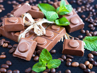 Chocolate and coffee beans and mint on a dark background