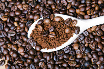 Iinstant coffee in spoon on coffee beans background