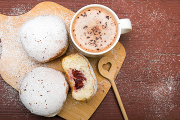 Classic donuts with powdered sugar, on wooden background