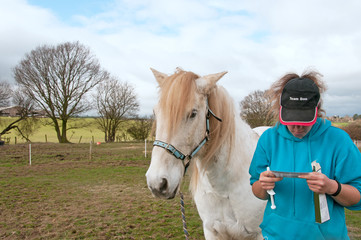 Owner reading the instructions before administering a wormer to her horse