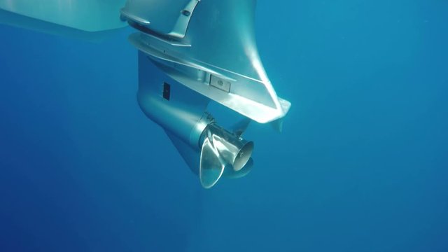 Underwater shot of propeller of powerful outboard engine starting.