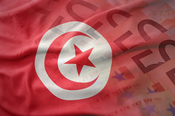 colorful waving national flag of tunisia on a euro money banknotes background. finance concept