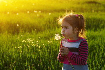 Girl blowing dandelion