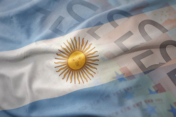 colorful waving national flag of argentina on a euro money banknotes background. finance concept