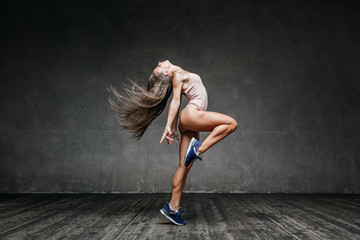 Young beautiful fitness female posing in studio