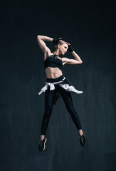 Young beautiful fitness female posing in studio