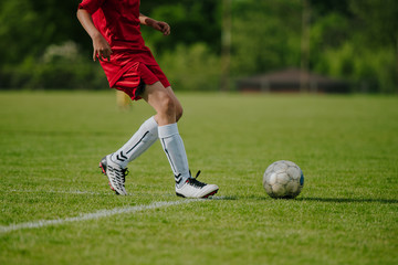 Młody piłkarz gra na trawiastym boisku