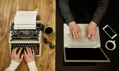 Woman writing on a typewriter and a man working on a laptop.