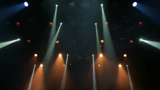 Floodlights, head, scanners, the theatrical smoke on the stage of the theatre during the performance. Lighting equipment. The lighting effects. Dynamic light.