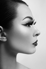 Black and white profile portrait of young beautiful woman with stylish eyeliner