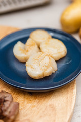 Fried Scallops Topping with Pepper on Blue Ceramic Plate on Wood Panel with Sea Salt and Vegetable Decorated.