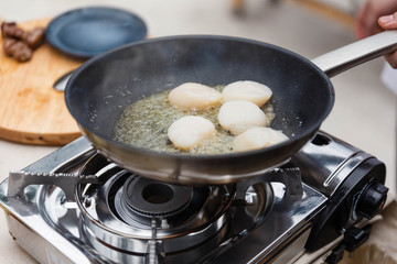 Chef Fried Scallops with Rosemary Oil in Pan with Spoon.